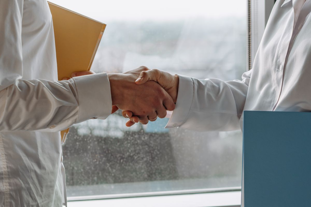 Close-up photograph of two professionals shaking hands